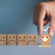 Smiling and frowning wooden blocks illustrating the power of choice and how our thinking shapes our experience.