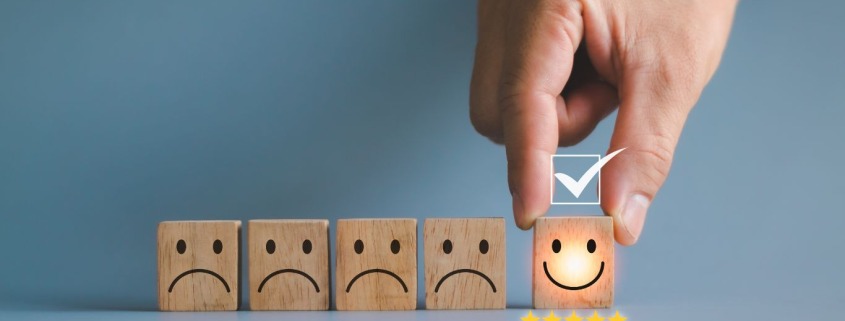 Smiling and frowning wooden blocks illustrating the power of choice and how our thinking shapes our experience.